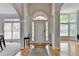 Bright foyer with high ceilings, hardwood floors, arched doorway, and views of adjacent living spaces at 5915 Masters Club Dr, Suwanee, GA 30024