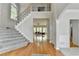 Open foyer featuring hardwood floors, carpeted staircase, and views into the living room at 5915 Masters Club Dr, Suwanee, GA 30024