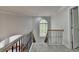 Upstairs hallway featuring railing and a light-filled arched window at 5915 Masters Club Dr, Suwanee, GA 30024