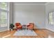 Cozy living room featuring hardwood floors, a bay window, two orange armchairs, and accent rug at 5915 Masters Club Dr, Suwanee, GA 30024