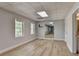 An airy living room features wood-look floors, two windows and neutral paint at 5915 Masters Club Dr, Suwanee, GA 30024