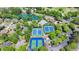 Aerial view of a recreational area featuring tennis courts, pools, and community facilities amid lush greenery at 5915 Masters Club Dr, Suwanee, GA 30024