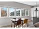 Sunlit dining area with modern table set near large windows and an open-concept kitchen at 611 King Arnold St, Atlanta, GA 30354