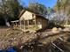 A fixer-upper house with wooden frame and porch, surrounded by debris and trees at 1386 Highway 92 S, Fayetteville, GA 30215