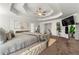 Spacious main bedroom featuring a tufted bed and ceiling fan at 220 Gucci Cir, Stockbridge, GA 30281