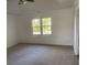 Bright bedroom featuring carpet flooring and a large window at 11564 Holly Ln, Hampton, GA 30228