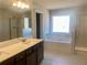 A modern bathroom with double vanity sinks, a soaking tub, and a walk-in shower at 405 Westmarch Cir, Loganville, GA 30052