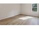 Bedroom features wood-look flooring, a large window, and neutral paint at 405 Westmarch Cir, Loganville, GA 30052