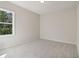 This bright bedroom features neutral carpet, paint, and a large window at 405 Westmarch Cir, Loganville, GA 30052
