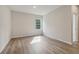 Bedroom features wood-look flooring, large window, and neutral paint at 405 Westmarch Cir, Loganville, GA 30052