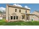 Beautiful tan home featuring a covered patio and green lawn surrounded by blue skies at 405 Westmarch Cir, Loganville, GA 30052