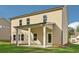 Beautiful tan home featuring a covered patio, green lawn, and neutral exterior at 405 Westmarch Cir, Loganville, GA 30052