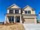 Two-story home with a two-car garage and a charming brick and tan exterior at 405 Westmarch Cir, Loganville, GA 30052