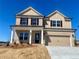 New two-story brick home with a two-car garage, classic design, and well-lit exterior at 405 Westmarch Cir, Loganville, GA 30052