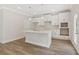 Modern kitchen with white cabinets, tiled backsplash, stainless steel faucet, island, and pendant lighting at 405 Westmarch Cir, Loganville, GA 30052