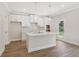 Modern kitchen with stainless steel faucet, white cabinets, tile backsplash, and island with pendant lights at 405 Westmarch Cir, Loganville, GA 30052