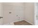 Laundry room features modern flooring, storage shelf, and washer/dryer hookups at 405 Westmarch Cir, Loganville, GA 30052