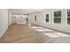 Open concept living room area flowing into kitchen with island, modern recessed lighting and lots of natural light at 405 Westmarch Cir, Loganville, GA 30052