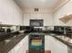Kitchen features black countertops, mirrored backsplash, white cabinets, and black appliances at 2479 Peachtree Ne Rd # 407, Atlanta, GA 30305