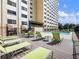 Community pool deck with lots of green lounge chairs and outdoor seating with a high-rise building view at 2479 Peachtree Ne Rd # 407, Atlanta, GA 30305