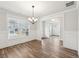 Bright dining room featuring hardwood floors, decorative chandelier, and large window with neighborhood views at 407 Westmarch Cir, Loganville, GA 30052