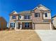 Charming two-story home featuring a stone and brick facade, complemented by a two-car garage at 407 Westmarch Cir, Loganville, GA 30052