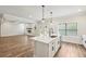 Modern open-concept kitchen with island, stainless steel appliances, and wood floors at 407 Westmarch Cir, Loganville, GA 30052