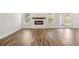 Bright living room featuring hardwood floors, a modern fireplace, large windows, and access to the backyard at 407 Westmarch Cir, Loganville, GA 30052