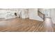 Open-concept area with hardwood floors, a staircase, and view into a modern kitchen with island at 407 Westmarch Cir, Loganville, GA 30052