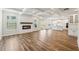 Open-concept space with fireplace, hardwood floors, coffered ceiling and view to kitchen at 407 Westmarch Cir, Loganville, GA 30052
