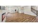 Spacious open-concept area with modern fireplace, hardwood floors, staircase, and view into the kitchen at 407 Westmarch Cir, Loganville, GA 30052