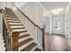 Elegant staircase with stained wood steps and railing with black iron balusters at 407 Westmarch Cir, Loganville, GA 30052