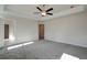 Bright main bedroom with tray ceiling, ceiling fan, and plush gray carpet at 414 Westmarch Cir, Loganville, GA 30052
