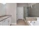 Bathroom featuring double vanity, walk-in shower with glass door, and a soaking tub at 505 Flyingbolt Run, Canton, GA 30115
