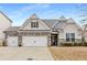 Charming home featuring a two-car garage, stone accents, and inviting curb appeal at 505 Flyingbolt Run, Canton, GA 30115