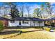 Charming ranch home with white exterior, black accents, and landscaped lawn at 2745 Fairlane Se Dr, Atlanta, GA 30354