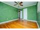 Bedroom with green walls, hardwood floors and ceiling fan at 6531 Temple St, Lithia Springs, GA 30122