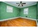 Bedroom with green walls, hardwood floors and ceiling fan at 6531 Temple St, Lithia Springs, GA 30122