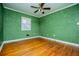 Bedroom with green walls, hardwood floors and ceiling fan at 6531 Temple St, Lithia Springs, GA 30122