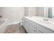 Bright bathroom with double vanity, white cabinets, and a separate bathtub and toilet at 7116 Fringe Flower Dr # 19, Austell, GA 30168