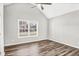 Bright bedroom with vaulted ceiling, large window, and wood-look flooring at 215 Prominent Loop, Mcdonough, GA 30253