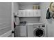 Bright laundry room with washer, dryer, and cabinets at 2820 Ashton Tree Ct, Dacula, GA 30019