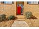 Red front door with brick steps and landscaping at 3318 Northcrest Rd # D, Atlanta, GA 30340