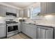 Modern kitchen with gray cabinets, granite counters, and stainless steel appliances at 2885 Field Spring Dr, Lithonia, GA 30058