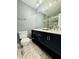 Bathroom featuring a black double sink vanity and white marble-look floor and shower tile at 5409 Mill Valley Dr, Douglasville, GA 30135
