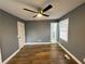 Bedroom featuring wood laminate flooring, dark grey walls, closet, window, and ceiling fan at 5409 Mill Valley Dr, Douglasville, GA 30135