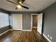Bedroom featuring wood laminate flooring, dark grey walls, closet, window, and ceiling fan at 5409 Mill Valley Dr, Douglasville, GA 30135