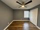 Bedroom featuring wood laminate flooring, dark grey walls, closet, window, and ceiling fan at 5409 Mill Valley Dr, Douglasville, GA 30135