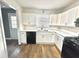 Kitchen sink with white cabinets, countertops, black dishwasher, and an outside door at 5409 Mill Valley Dr, Douglasville, GA 30135