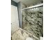 Updated shower featuring white marble-look tile, glass doors, and a built-in niche at 5409 Mill Valley Dr, Douglasville, GA 30135